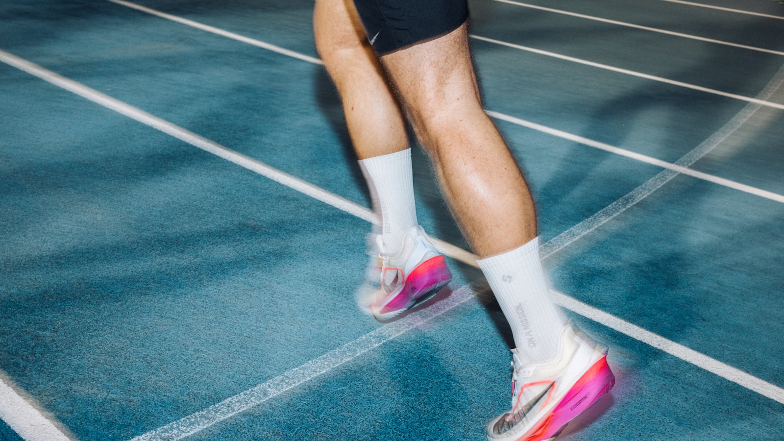 Runner’s calves and Achilles tendons driving off a track — the push-off load that provokes Achilles tendonitis in Tampa runners.