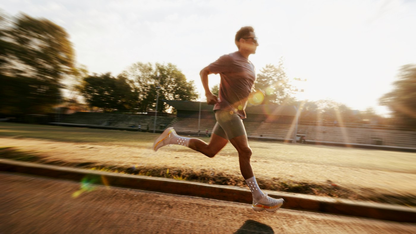 Runner at speed on a track at sunrise — the graded return to sprinting that ends hamstring strain rehab for Tampa runners and hybrid athletes.