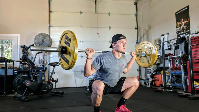 Lifter at the bottom of a deep barbell back squat — meniscus tear physical therapy guide at Forward Physio Tampa